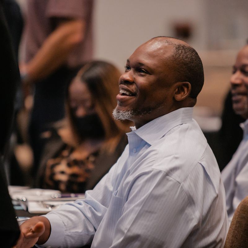 A pastor laughing among friends after the service